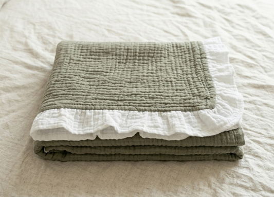 Organic 4-layer
muslin baby blanket
in Olive Green with
white ruffle border by
Baby DukWear Inc.